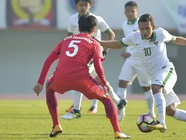 Gelandang Indonesia U-19, Egy Maulana Vikri, berusaha melewati pemain Korea Selatan (Korsel) pada kualifikasi Piala Asia U-19 2018 di Stadion Paju, Sabtu (4/11/2017). Korsel menang 4-0 atas Indonesia. (AFP/Kim Doo-Ho)