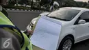 Petugas saat menegur pengendara di jalan Medan Merdeka Barat, Jakarta, Jumat (5/8). Berdasarkan data Polda Metro Jaya, terhitung 27 Juli hingga 3 Agustus 2016 jumlah pelanggaran ganjil-genap mencapai 5.947 pelanggar. (Liputan6.com/Yoppy Renato)