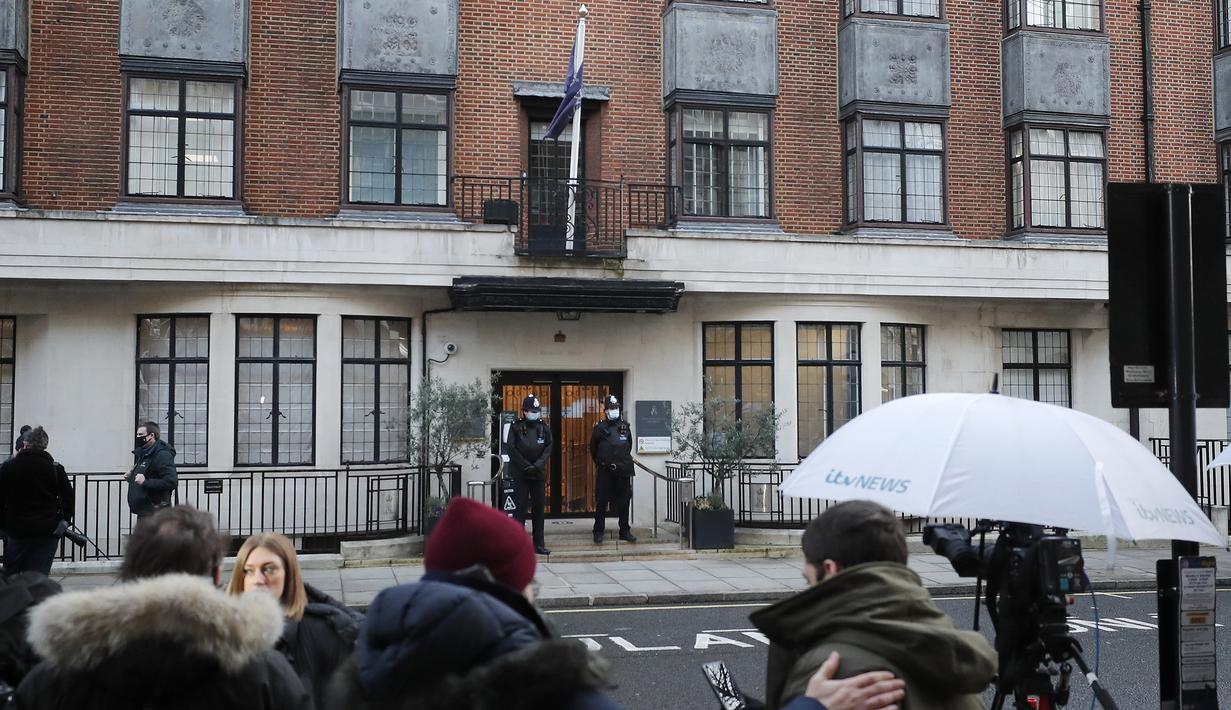 Awak media mengamati saat polisi berjaga di luar rumah sakit King Edward VII di London, Kamis (18/2/2021). Pihak keluarga kerajaan Inggris mengatakan suami Ratu Elizabeth II, Pangeran Philip (99), dirawat di rumah sakit setelah merasa tidak enak badan pada Selasa malam. (AP Photo/Frank Augstein)
