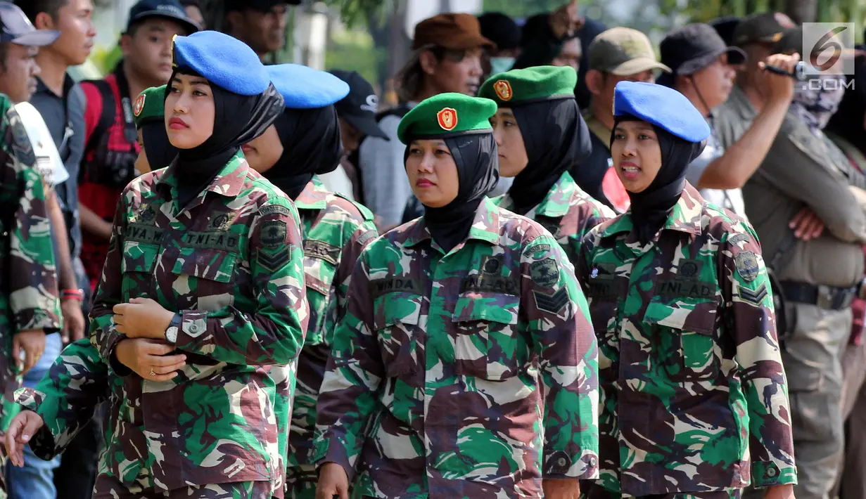 Aparat TNI wanita berjaga saat Hari Buruh Sedunia di depan Istana Negara, Jakarta, Selasa (1/5). Memperingati Hari Buruh 2018, ribuan buruh mulai memadati Istana Kepresidenan, Jakarta Pusat. (Liputan6.com/Johan Tallo)