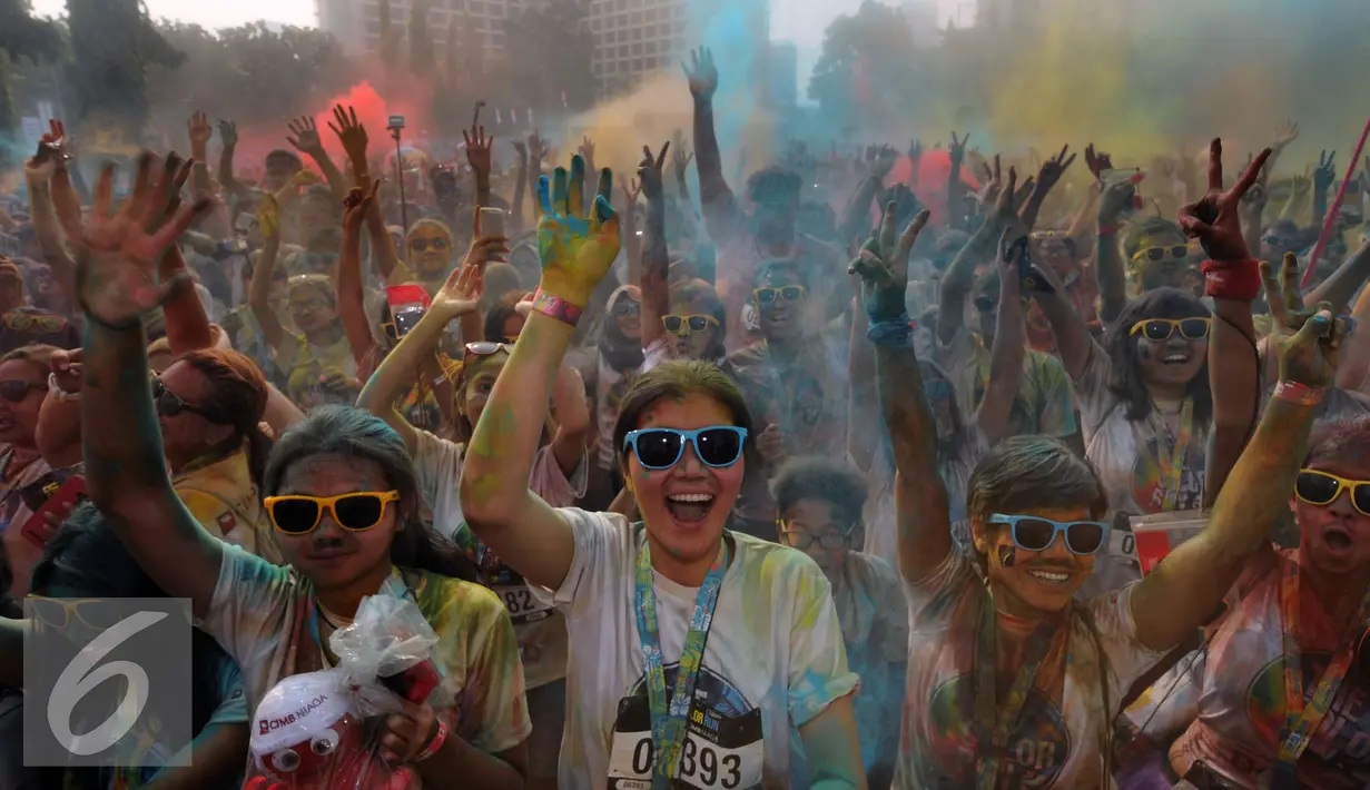 Ribuan orang mengangkat tangan saat berpesta pada puncak event lari santai 5K Colour Run 2016 di Parkir Timur Senayan, Jakarta, Minggu (7/8). Event ini mempromosikan gaya hidup sehat penuh kegembiraan. (Liputan6.com/Helmi Fithriansyah)