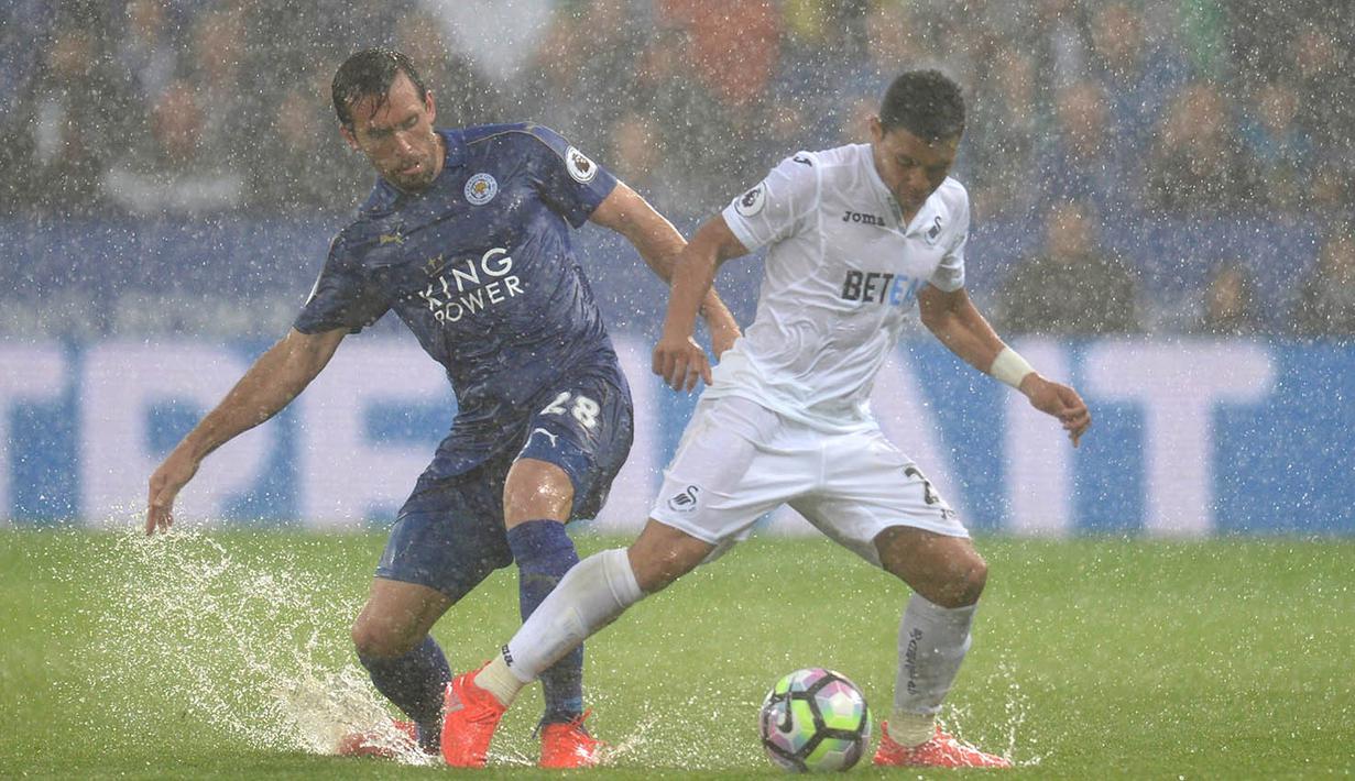 Air menggenangi lapangan Stadion King Power, Leicester, Inggris, saat laga Premier League antara Leicester melawan Swansea. Hujun deras yang menguyur sebagian Inggris membuat beberapa laga Liga Inggris berjalan dalam guyuran hujan. (AFP/Oli Scarff)