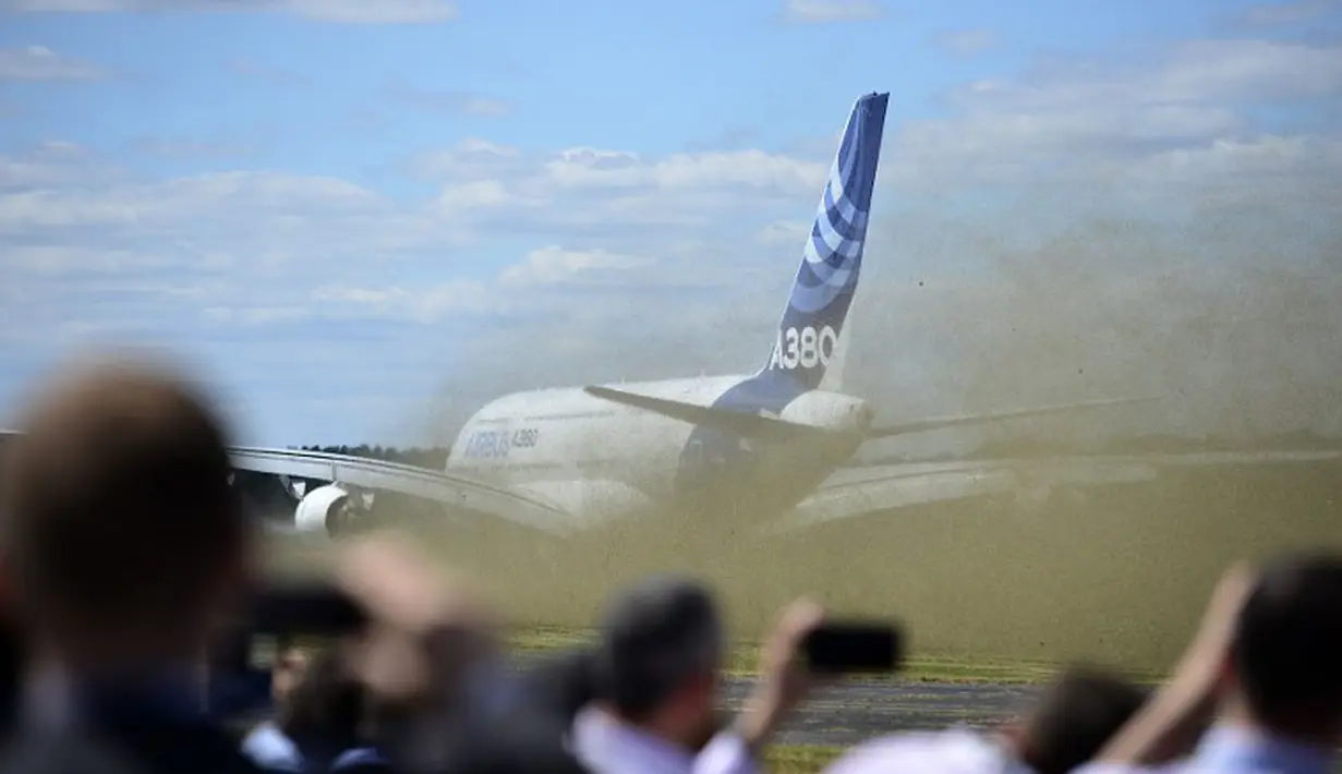 Pengunjung pameran menyaksikan detik-detik lepas landasnya Airbus A380-800 yang melakukan demo terbang di Farnborough Airshow di Hampshire, Inggris, (14/7/2014). (AFP PHOTO/Carl Court)  
