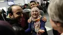 Pengungsi asal Suriah Baraa Haj Khalaf tersenyum saat disambut keluarganya di bandara Internasional O'Hare, AS, Rabu (7/2). Baraa dan keluarganya harus menjalani introgasi panjang agar bisa melewati otoritas bandara. (AFP Photo/ Scott Olson)
