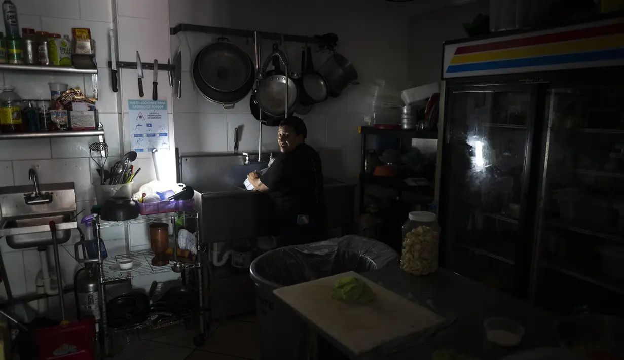Karyawan Las Palmas Cafe bekerja dengan generator listrik di San Juan, 7 April 2022. Lebih dari satu juta pelanggan di Puerto Rico tetap tanpa listrik setelah kebakaran di pembangkit listrik utama yang menyebabkan pemadaman terbesar sepanjang tahun ini di seluruh wilayah AS. (AP Photo/Carlos Giusti)