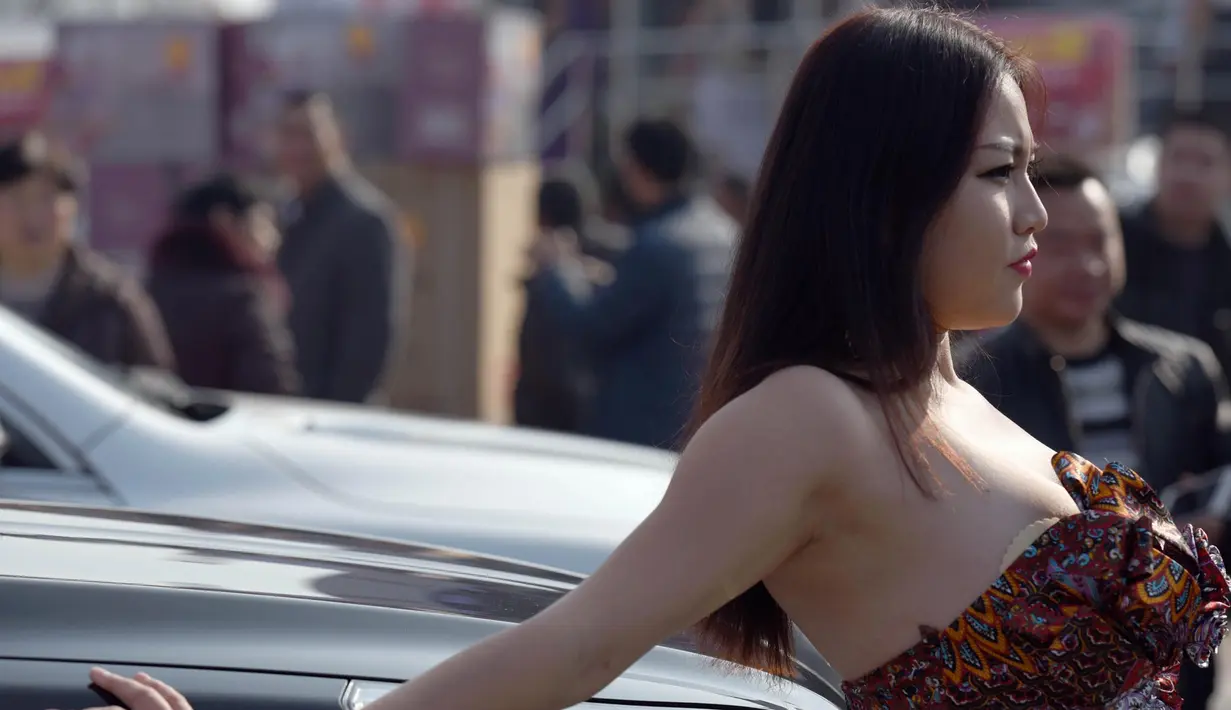 Jiang Qing berpose di sebuah mobil saat pameran mobil di Provinsi Jiangsu, Tiongkok. Jiang Qing adalah juara pertama dari Kejuaraan "Payudara Terindah" yang diadakan pada Oktober 2015. (30/11/2015) (shanghaiist.com)