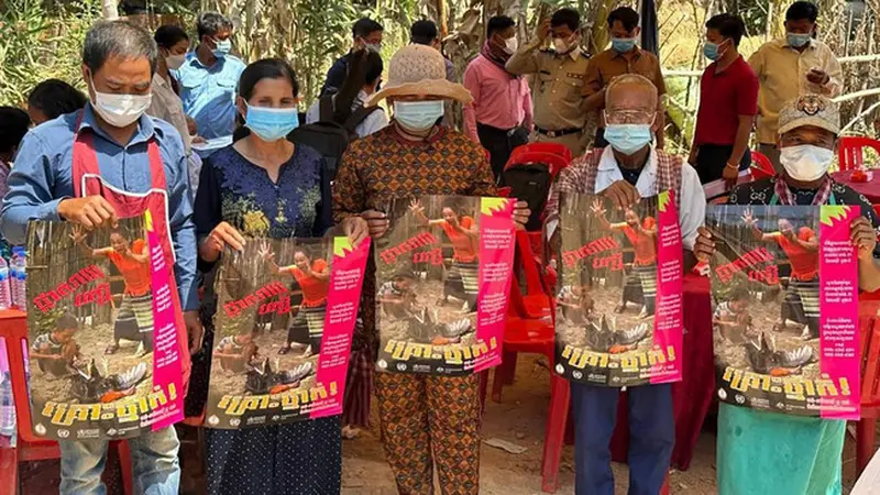 Penduduk desa Kamboja memegang poster untuk menyebarkan kesadaran akan flu burung.