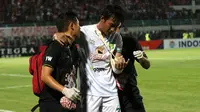 Bek tengah Persebaya Surabaya, Hansamu Yama Pranata, harus keluar dari lapangan sambil menggunakan penyangga tangan saat timnya bertanding dengan Madura United dalam laga pekan ke-30 Shopee Liga 1 2019, Senin (2/12/2019). (Bola.com/Aditya Wany)