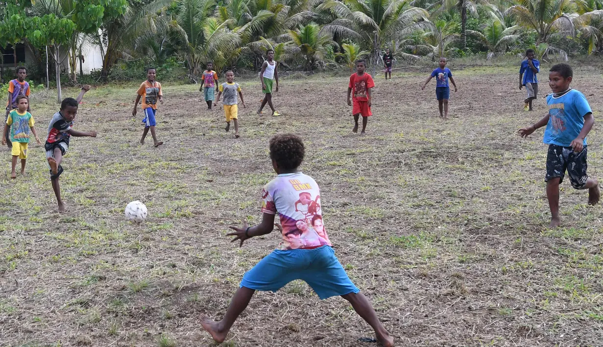 Sejumlah anak dari suku Byak Betew bermain sepak bola setelah misa hari Minggu di pulau Saukabu, satu dari 1.500 pulau di Raja Ampat 20 Agustus 2017. Raja Ampat  yang berarti Empat Raja terdiri dari 1.500 pulau. (AFP Photo/Goh Chai Hin)