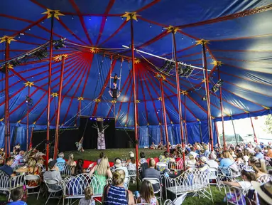 Akrobat di bawah tenda besar memukau penonton selama pertunjukan Flynn Creek Circus di Avon, Colorado (14/8/2021). Pertunjukkan ini menerapkan tempat duduk ramah Covid-19 dengan meja individu per pesta. (Chris Dillmann/Vail Daily via AP)