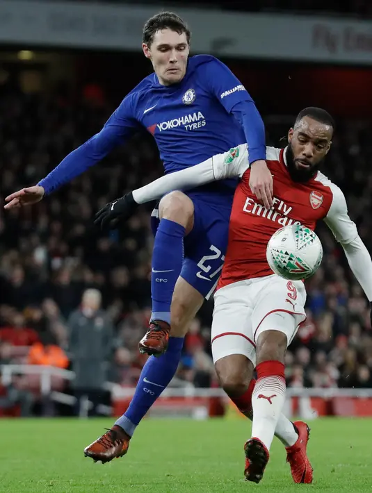 Pemain Arsenal, Alexandre Lacazette berebut bola dengan pemain Chelsea, Andreas Christensen pada laga leg kedua babak semifinal Piala Liga di Stadion Emirates, Kamis (25/1). Tiket final Piala Liga jatuh ke tangan Arsenal usai menang 2-1. (AP/Matt Dunham)