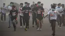 Para peserta mengikuti lomba lari New Delhi 10K menggunakan masker ditengah-tengah kabut polusi yang menimpa kota New Delhi, India (6/11). Kabut polusi ini menimbulkan partikel yang menggangu kesehatan. (AFP/Dominique Faget)