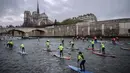 Para peserta mengambil bagian dalam Nautic Paddle Race di Paris, Minggu (9/12). Sekitar 800 orang mengikuti lomba dayung sambil berdiri terbesar di dunia sejauh 11 km dengan pemandangan kota Paris. (Lucas BARIOULET/AFP)