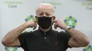 Presiden terpilih Amerika Serikat, Joe Biden merapikan masker usai menerima dosis kedua vaksin COVID-19 Pfizer di Rumah Sakit Christiana di Newark, Delaware, Senin (11/1/2021). Sebelumnya, Biden mendapat suntikan pertamanya pada 21 Desember 2020 lalu. (Alex Wong/Getty Images/AFP)