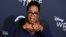 Aktris sekaligus presenter, Oprah Winfrey menghadiri premier film "A Wrinkle In Time" di Hollywood’s El Capitan Theater, Los Angeles, Senin (26/2). Oprah Winfrey datang dalam balutan Atelier Versace mididress warna navy. (Jordan Strauss/Invision/AP)