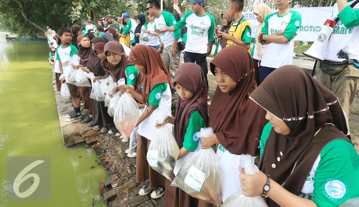 Para murid SDN Pamarican 2 Serang melakukan sebar sejuta ikan di danau Tasikardi, Serang Baten, Sabtu (28/5). Jurnalis Joran Indonesia (Jojoners) dan PT Hero Supermarket Tbk mengadakan gerakan kepedulian sosial dan lingkungan. (Liputan6.com/Angga Yuniar)