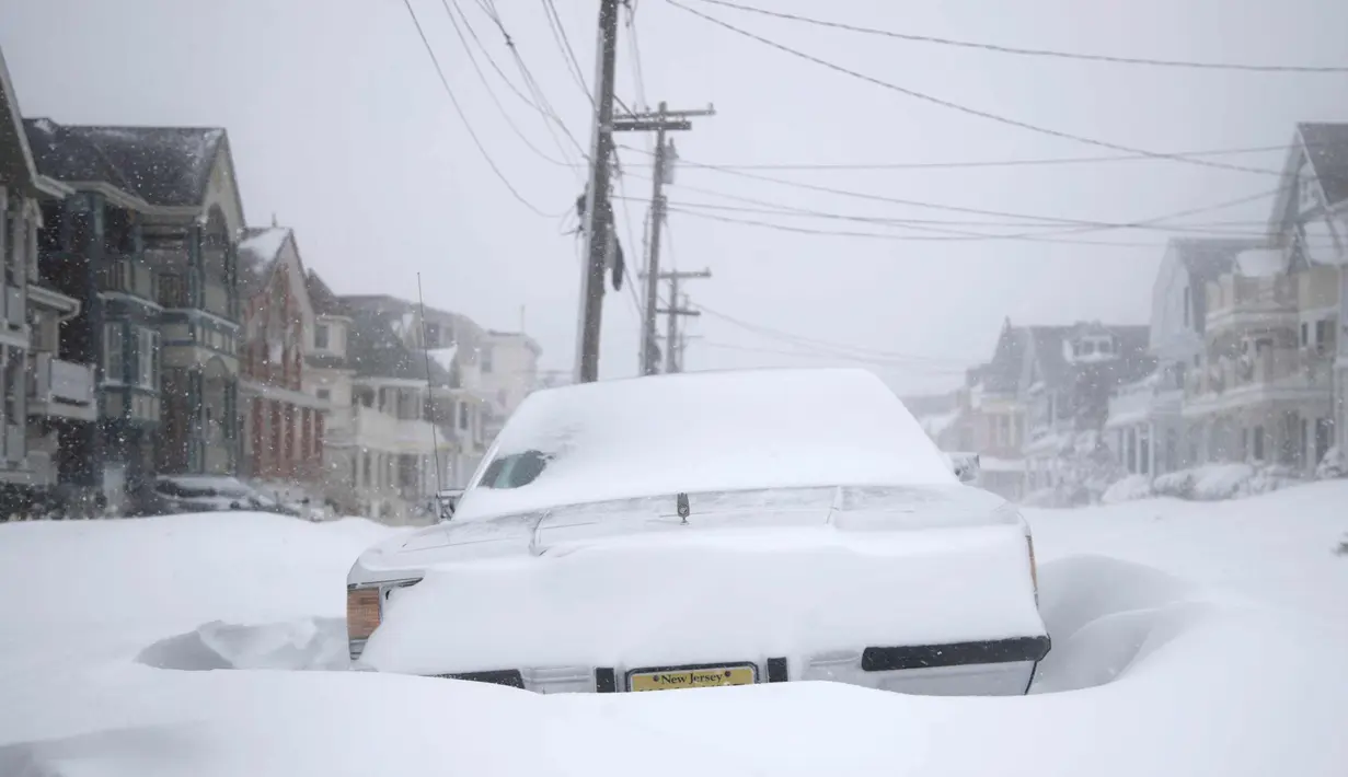 Sebuah mobil yang diselimuti salju selama badai yang menghantam pesisir New Jersey (4/1). (AP Photo / Julio Cortez)