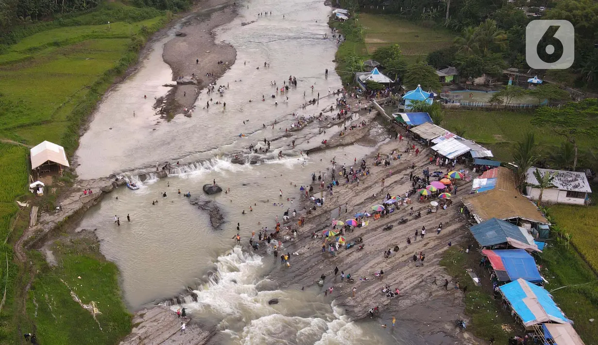 <p>Foto udara menunjukkan wisatawan  berenang di aliran sungai Cipamingkis  Kecamatan Sukamakmur, kabupaten Bogor, Jawa Barat, Kamis (5/5/2022). Warga memanfaatkan aliran sungai tersebut sebagai sarana hiburan Hari Raya Idul Fitri 1443 Hijriah. (merdeka.com/Imam Buhori)</p>