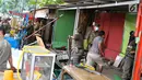 Petugas Satpol PP membongkar bangunan semi permanen di Jalan Nusantara Raya, Depok, Jawa Barat, Rabu (18/4). Pembongkaran dilakukan untuk menertibakan bangunan liar yang juga berdiri di atas saluran air. (Liputan6.com/Immanuel Antonius)