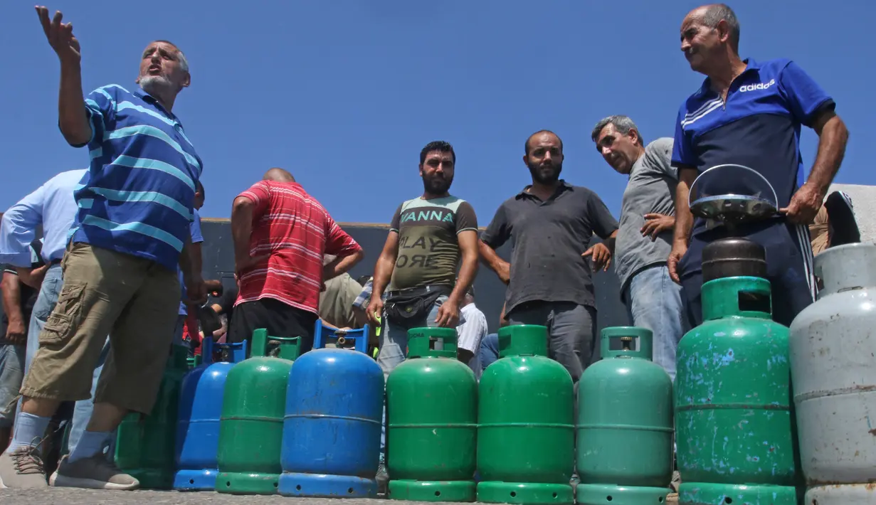 Warga Lebanon menunggu untuk mengisi tabung gas di tengah krisis ekonomi yang semakin parah di kota selatan Sidon, Selasa (10/8/2021). Krisis ekonomi yang dihadapi Lebanon diakui Bank Dunia sebagai salah satu yang terburuk di planet ini sejak pertengahan abad ke-19. (Mahmoud ZAYYAT/AFP)