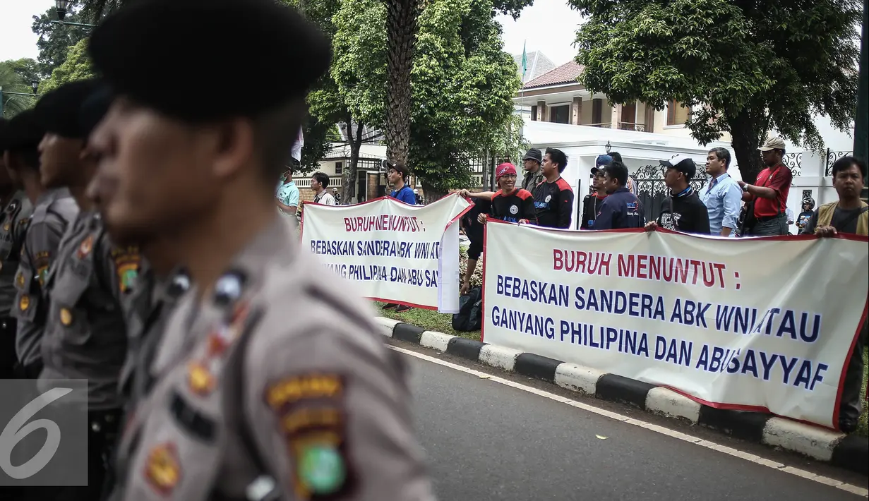 Para pengunjuk rasa membentangkan spanduk dijalan saat melakukan orasi di depan Kedutaan Besar Filipina, Jakarta, Kamis (14/7). Dalam aksinya mereka menuntut agar ABK WNI yang disandera di Filipina dibebaskan. (Liputan6.com/Faizal Fanani)