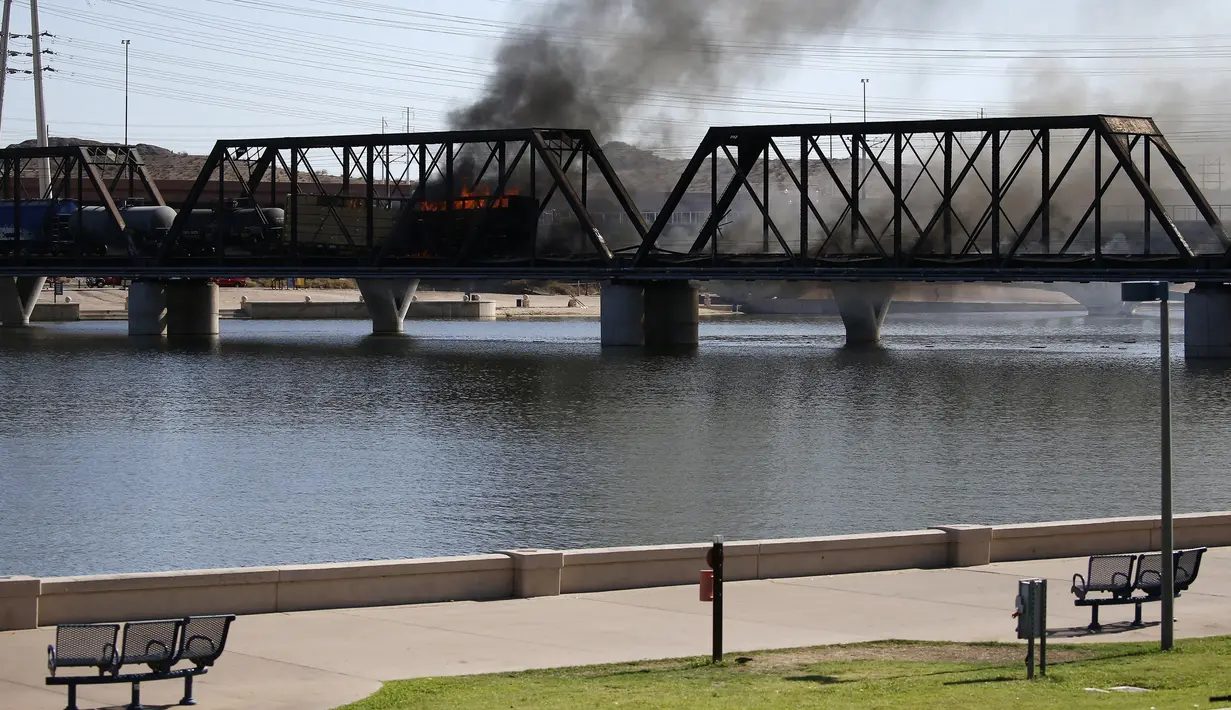 Kereta barang tergelincir dan terbakar di jembatan Danau Kota Tempe, Arizona, Amerika Serikat, Rabu (29/7/2020). Kecelakaan memicu kebakaran hebat dan terlihat beberapa kilometer. (AP Photo/Ross D. Franklin)
