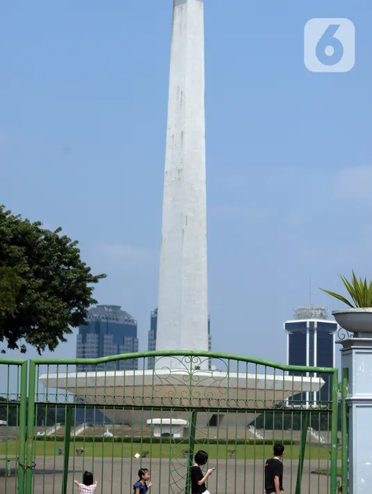 Warga berjalan di depan pagar Monumen Nasional (Monas), Jakarta, Sabtu (15/5/2021). Warga kecewa lantaran tempat wisata tersebut ditutup, padahal mereka datang untuk menikmati libur Idul Fitri 1442 Hijriah. (merdeka.com/Imam Buhori)