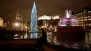 Warga duduk dekat pohon Natal setelah tradisi penyalaan lampu di Trafalgar Square, London, Kamis (6/12). Setiap tahun London mendapat pohon Natal dari Norwegia sebagai tanda terima kasih atas dukungan Inggris selama perang dunia II. (AP/Matt Dunham)