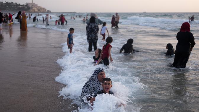 Muslim Palestina menikmati suasana libur Lebaran di pantai Tel Aviv, Israel, 6 Juni 2019. Selama Idul Fitri, pemerintah Israel mengizinkan warga Palestina mengunjungi negaranya untuk menandai berakhirnya ibadah puasa Ramadan. (AP Photo/Oded Balilty)