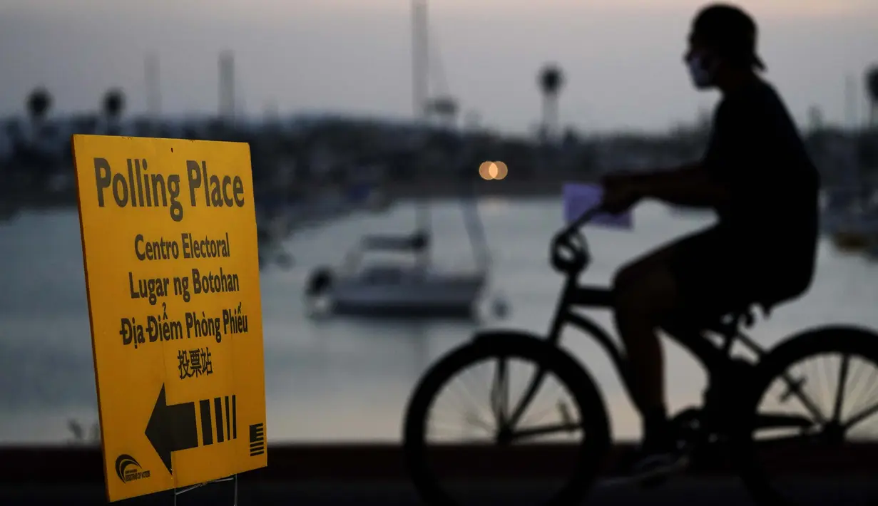 Seorang pria melewati tanda tempat pemungutan suara pada Hari Pemilihan di San Diego, Amerika Serikat, Selasa (3/11/2020). (AP Photo/Gregory Bull)