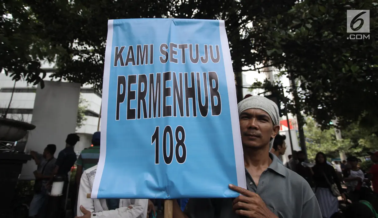 Massa menunjukkan poster dalam aksi mendukung Permenhub Nomor 108 Tahun 2017 di depan Kementerian Perhubungan, Jakarta, Kamis (1/2).  Massa menuntut pemerintah segera menerapkan Permenhub tersebut khususnya mengenai uji KIR. (Liputan6.com/Arya Manggala)