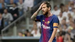 Striker Barcelona, Lionel Messi, memegang kepalanya usai takluk dari Real Madrid pada laga Piala Super Spanyol 2017 di Stadion Santiago Bernabeu, Rabu (16/8/2017). Real Madrid menang 2-0 atas Barcelona. (AFP/Curto De La Torre)