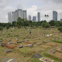 Pekerja membersihkan area makam di TPU Karet Bivak, Jakarta (2/2). Dinas Pertamanan dan Pemakaman telah menerapkan sistem online dalam pelayanan pemakaman di Ibu kota dengan alamat situs pertamananpemakaman.jakarta.go.id. (Liputan6.com/Gempur M Surya)