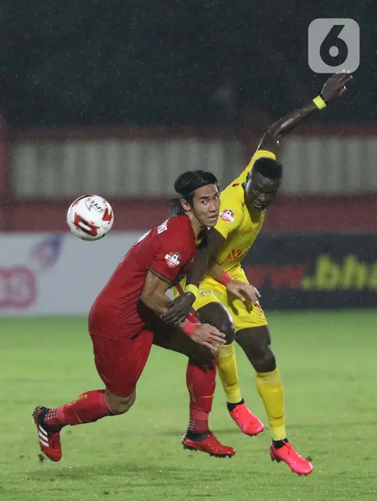 Pemain belakang Persija, Ryuji Utomo (kiri) berebut bola dengan penyerang Bhayangkara FC, Ezechiel Ndouasel pada lanjutan Shopee Liga 1 Indonesia di Stadion PTIK, Jakarta, Sabtu (14/3/2020). Laga kedua tim berakhir imbang 2-2. (Liputan6.com/Helmi Fithriansyah)