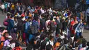 Pekerja migran berkumpul di luar daerah kumuh Dharavi menaiki bus menuju stasiun untuk mengambil layanan kereta api khusus di Mumbai, Selasa (12/5/2020). India mengoperasikan kereta api terbatas di tengah lockdown yang telah berjalan beberapa minggu akibat virus corona. (INDRANIL MUKHERJEE/AFP)