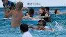 Pengunjung menghabiskan waktu di kolam renang di sebuah taman hiburan di Tokyo, Jepang (19/7). Badan Meteorologi Jepang mengumumkan Jepang tengah, termasuk Tokyo, telah menyelesaikan musim hujan 'Tsuyu'.  (AFP Photo/Toshifumi Kitamura)