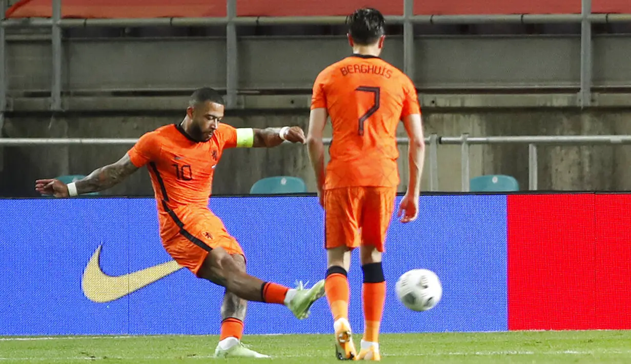 Pemain Belanda Memphis Depay menembak untuk mencetak gol ke gawang Skotlandia pada pertandingan persahabatan di Stadion Algarve, luar Faro, Portugal, Rabu (2/6/2021). Pertandingan berakhir imbang 2-2. (AP Photo/Miguel Morenatti)