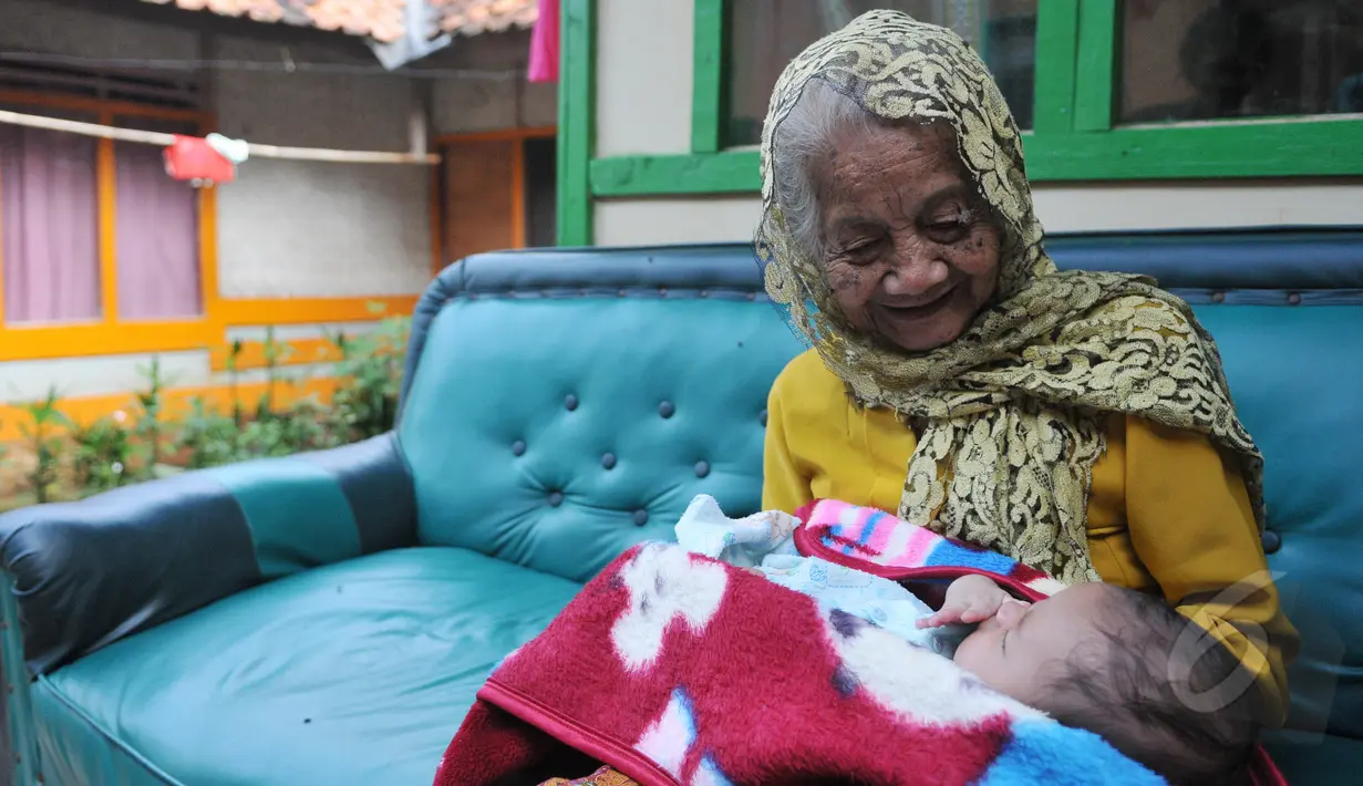 Nenek Anami terlihat menggendong seorang bayi di depan rumahnya di Purwakarta, Jabar, Minggu (17/5). Nenek yang diduga berusia 140 tahun ini akan mengikuti sayembara orang tertua di dunia dengan hadiah sekitar Rp13 miliar. (Liputan6.com/Herman Zakharia)