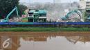 Sejumlah alat berat merobohkan bangunan di kawasan prostitusi Kalijodo, Jakarta Utara, Senin (29/2). Puluhan bangunan di kawasan tersebut mulai rata dengan tanah serta menjadi tontonan warga. (Liputan6.com/Gempur M Surya)