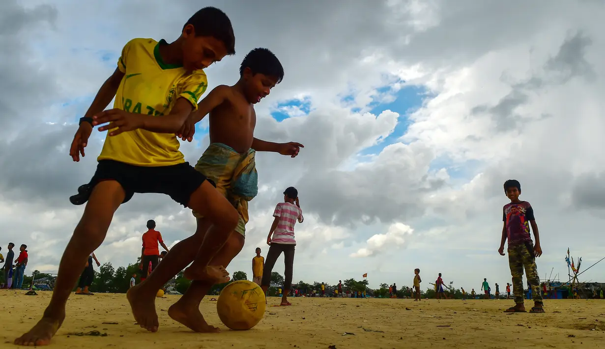 Anak-anak Rohingya bermain sepak bola di kamp pengungsi Kutupalong di Ukhia, Bangladesh, 19 Juli 2018. Piala Dunia 2018 mungkin sudah berakhir, namun demam pesta akbar sepak bola itu masih terasa di kamp pengungsi terbesar di dunia. (AFP/Munir UZ ZAMAN)