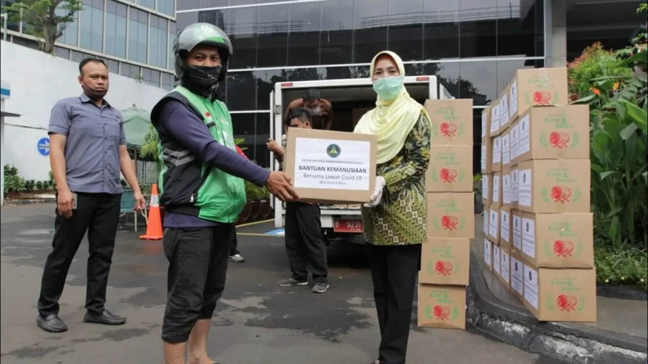 Ketua Umum IAD Pusat Sruningwati Burhanuddin membagikan paket sembako kepada salah seorang pengendara ojek daring di Rumah Dinas Kejaksaan Agung, Kamis (9/4/20202)