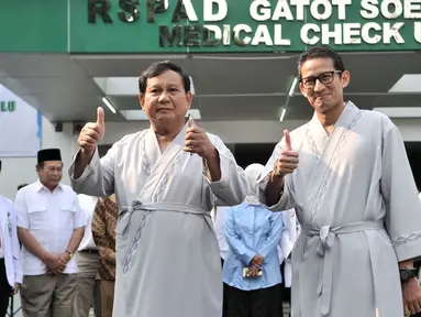 Bakal calon presiden dan wakil presiden Pilpres 2019, Prabowo Subianto (kiri) dan Sandiaga Uno menyapa awak media saat akan menjalanai pemeriksaan awal tes kesehatan di RSPAD Gatot Soebroto, Jakarta, Senin (13/8). (Merdeka.com/Iqbal S. Nugroho)