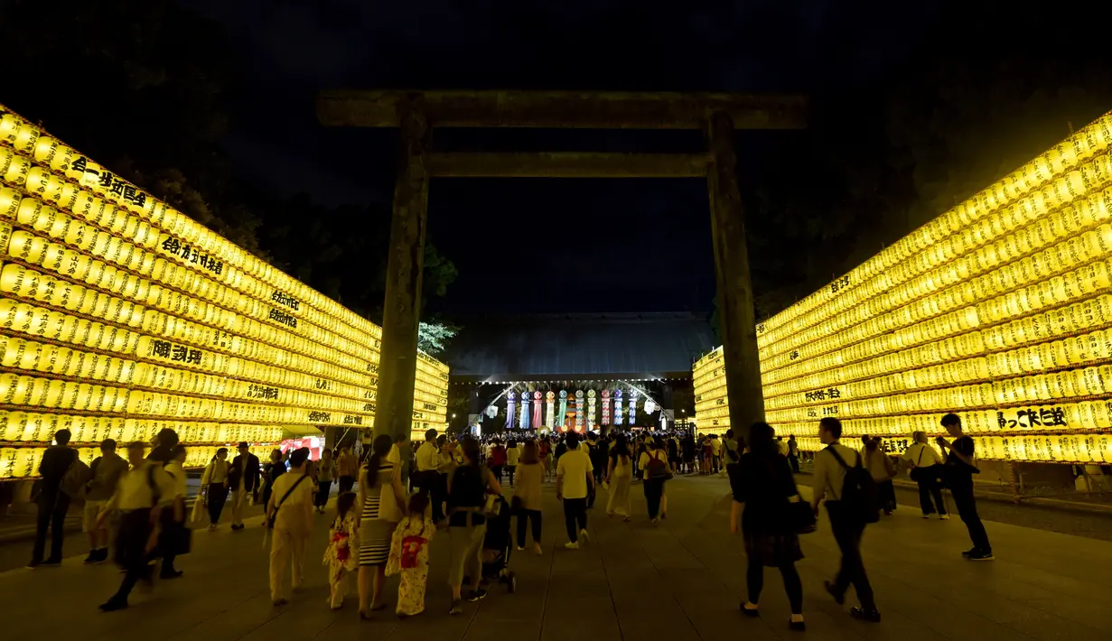 Sejumlah pengunjung melihat lentera yang memeriahkan Festival Mitama di Kuil Yasukuni, Tokyo, Jepang, (13/7). Sekitar 30.000 lentera menerangi daerah terseubt untuk mengenang korban perang.  (AFP Photo/Toru Yamanka)