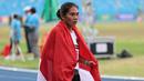 Pelari putri Indonesia, Odekta Elvina Naibaho membawa bendera Merah Putih setelah menyelesaikan nomor lari 10.000 meter SEA Games 2023 di Stadion Morodok Techo National Stadium, Phnom Penh, Kamboja, Jumat (12/5/2023). Odekta meraih medali perunggu dengan catatan waktu 35 menit 31,03 detik sementara medali emas dan perak direbut dua atlet Vietnam, Thi Oanh Nguyen (35 menit 11,53 detik) dan Thi Hong Le Pham (35 menit 21,09 detik). (Bola.com/Abdul Aziz)