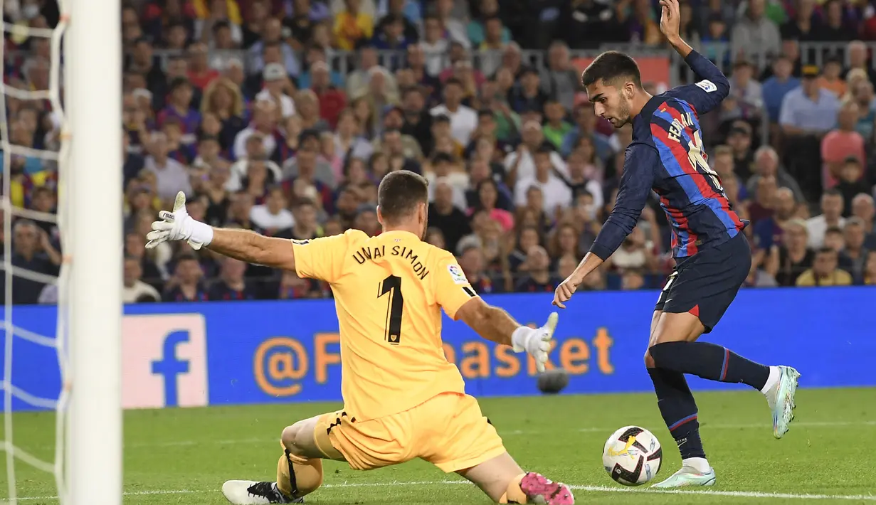 Pemain depan Barcelona Ferran Torres (kanan) bersaing dengan kiper Athletic Bilbao Unai Simon pada pekan ke-11 Liga Spanyol 2022/2023 di Camp Nou, Senin dini hari WIB (24/10/2022). Athletic Bilbao yang sudah berusaha mengimbangi permainan tuan rumah, gagal memperkecil ketinggalan. (Photo by Josep LAGO / AFP)