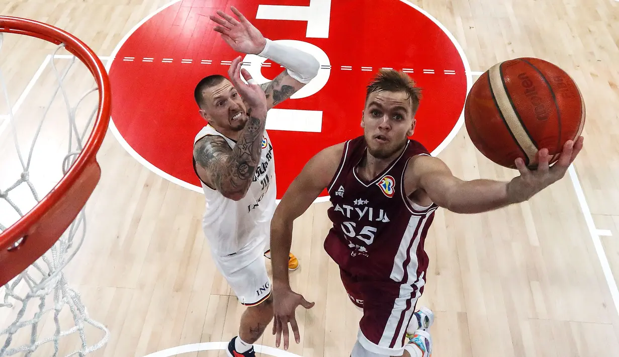 Arturs Zagars (kanan) dari Latvia melakukan drive ke keranjang melawan Daniel Theis dari Jerman pada pertandingan perempat final Piala Dunia Bola Basket, Rabu, 6 September 2023, di Manila, Filipina. (AP Photo/Yong Teck Lim via AP)