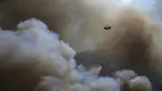 Sebuah helikopter berpartisipasi dalam operasi pemadaman kebakaran hutan di Koycegiz, Mugla, Turki, Senin (9/8/2021). Kebakaran hutan yang terjadi di tengah gelombang panas ganas telah berkobar selama berhari-hari di lebih dari setengah provinsi Turki. (AP Photo/Emre Tazegul)