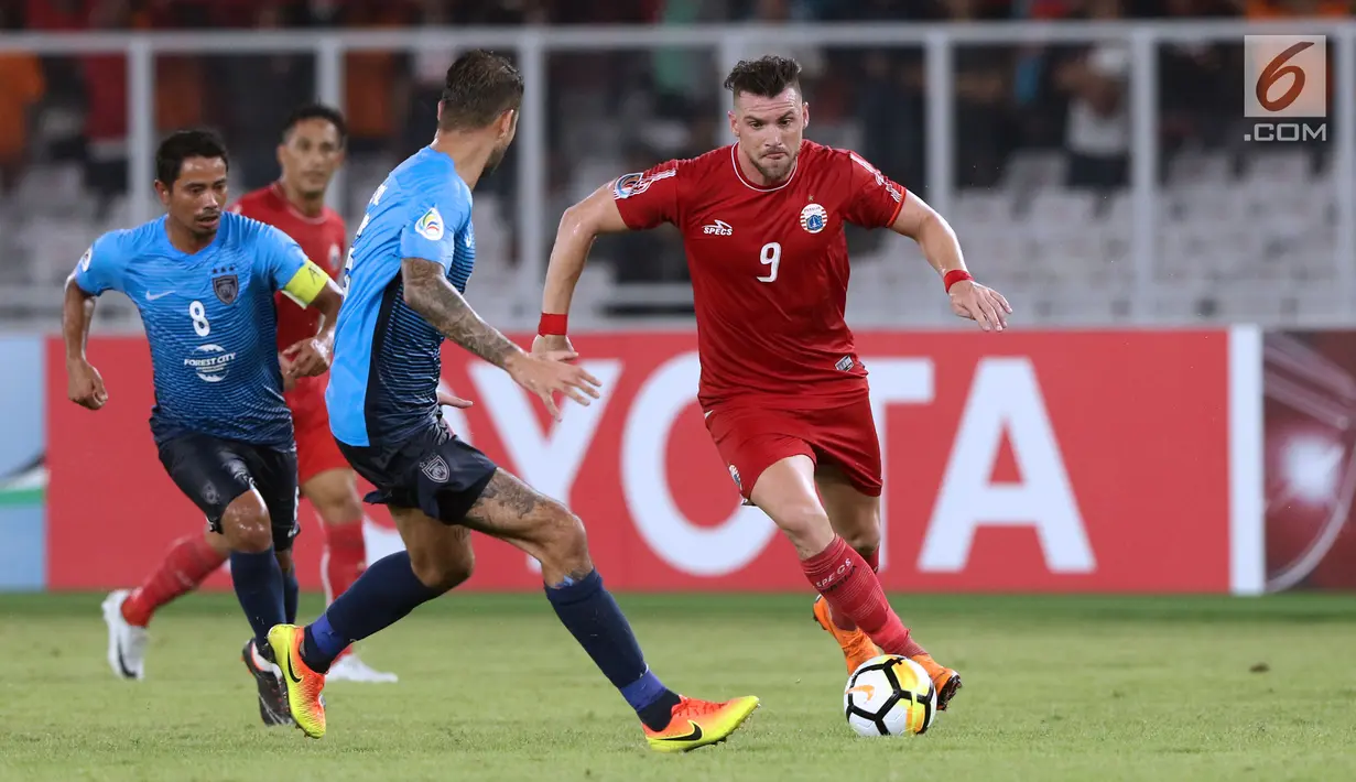 Pemain Persija, Marko Simic (kanan) mencoba melewati hadangan pemain Johor Darul Takzim pada lanjutan penyisihan Grup H Piala Asia 2018 di Stadion GBK, Jakarta, Selasa (10/4). Persija menang telak 4-0. (Liputan6.com/Helmi Fithriansyah)