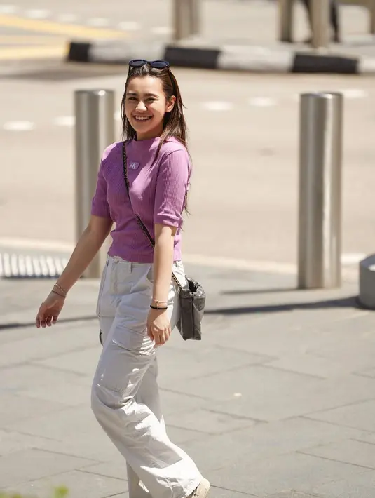 Gaya kasual super manis dari Aaliyah Massaid saat berada di Singapura. Ia mengenakan atasan berwarna ungu dipadu cargo pants putih. Riasan wajah minimalis dipagu dengan sunglasses dan rambut panjang lurus yang dibiarkan tergerai menyempurnakan penampilan Aaliyah secara keseluruhan. [Foto: Instagram/aaliyah.massaid]
