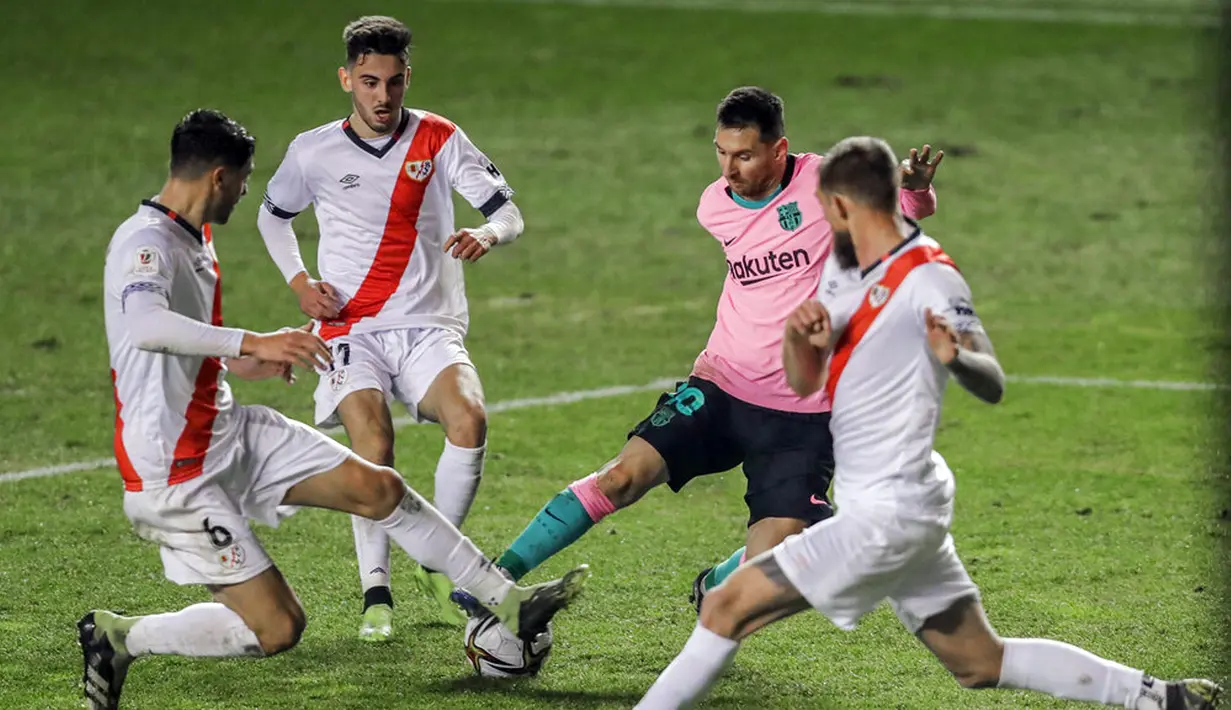 Pemain Barcelona Lionel Messi membawa bola melewati para pemain Rayo Vallecano pada pertandingan 16 besar Copa del Rey di Stadion Vallecas, Madrid, Spanyol, Rabu (27/1/2021). Barcelona melaju ke perempat final Copa del Rey usai mengalahkan Rayo Vallecano 2-1. (AP Photo/Manu Fernandez)